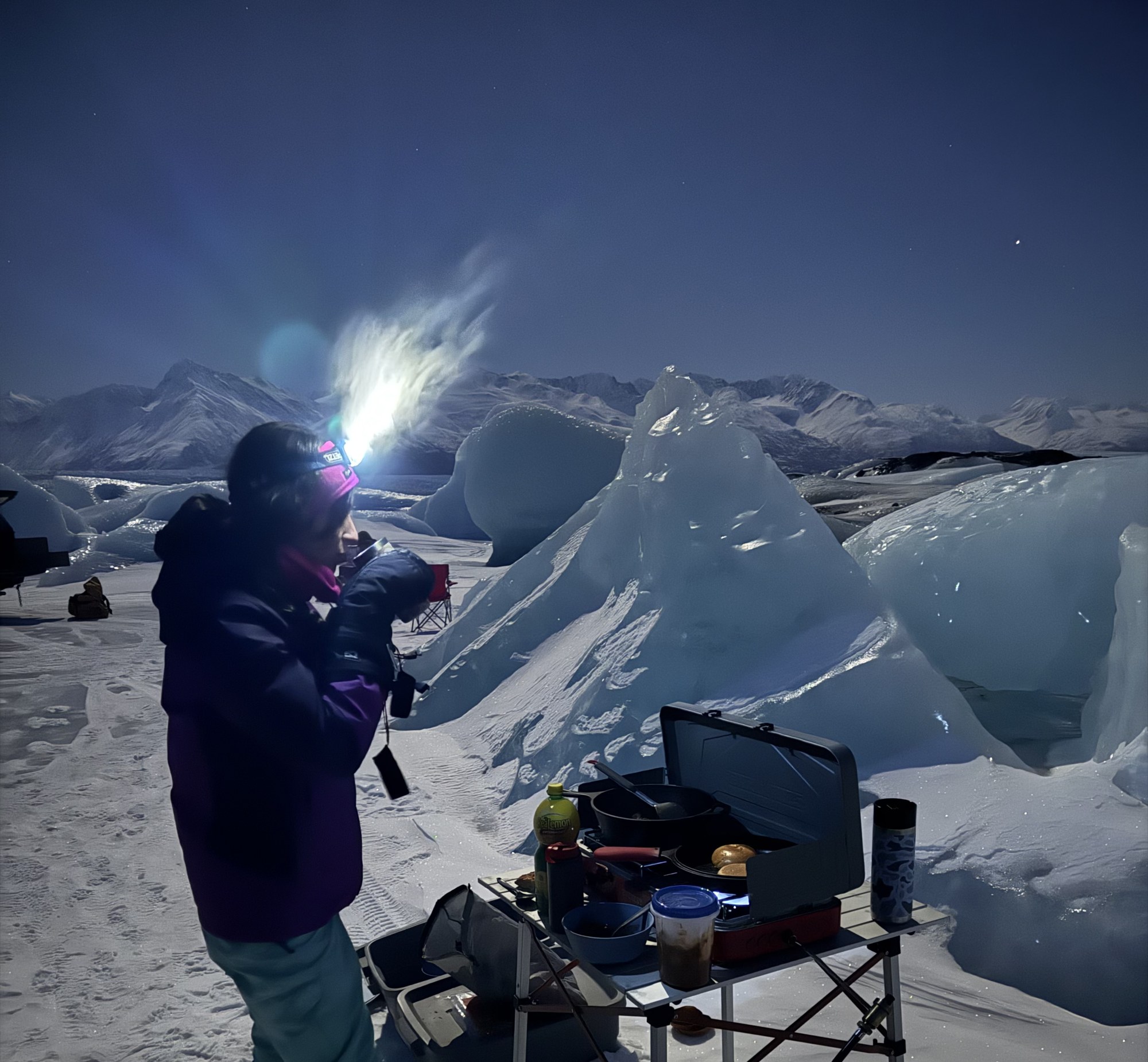Mona beside a camp stove among snow and ice