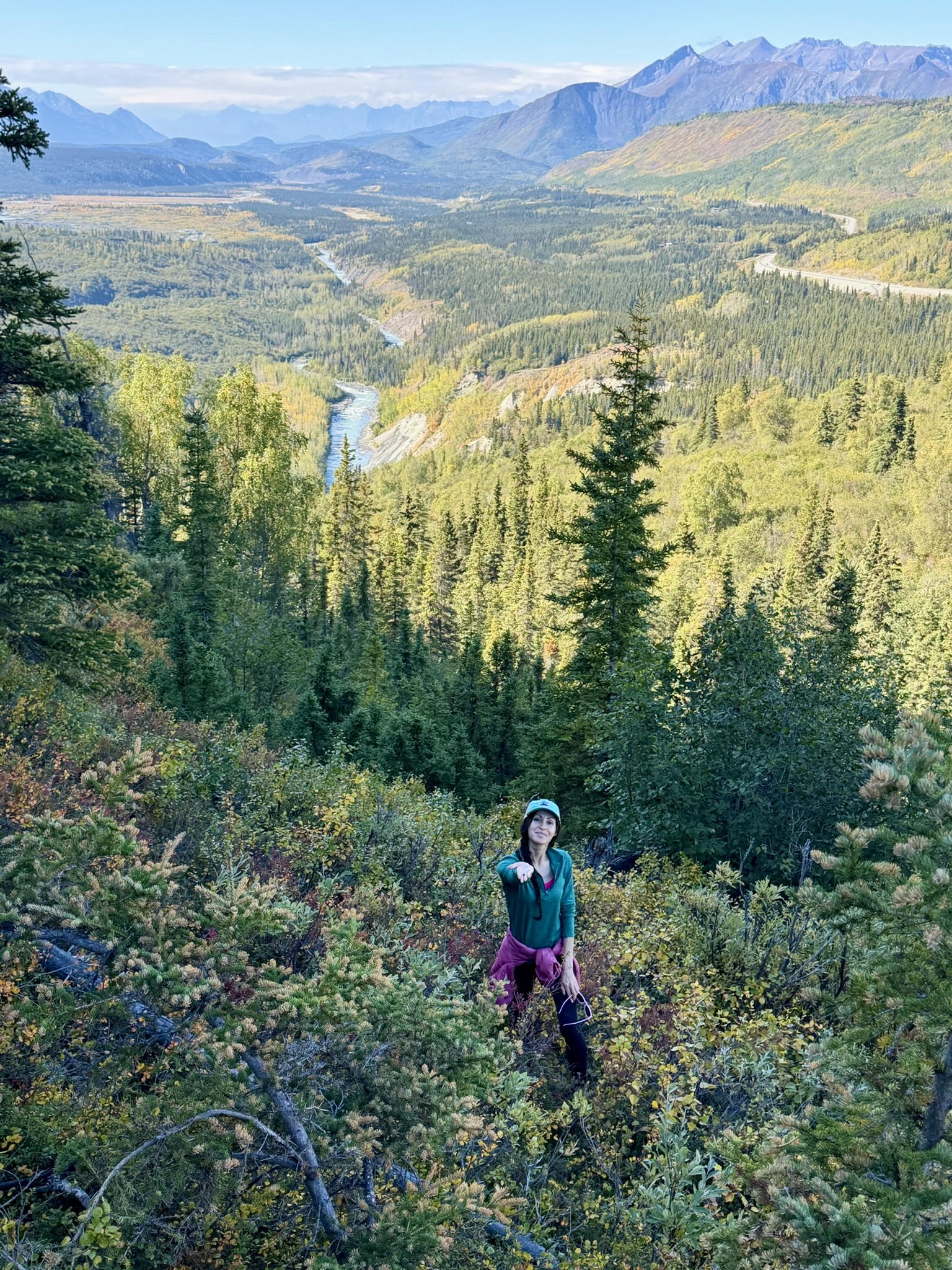 Mona holding out a blueberry above an Alaska valley